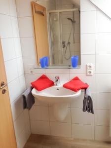 a bathroom with a white sink with red towels at Sonnenhof Kiekut in Norderney