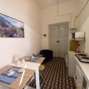 una piccola stanza con due tavoli e una cucina di AL CONVENTO a Scanno