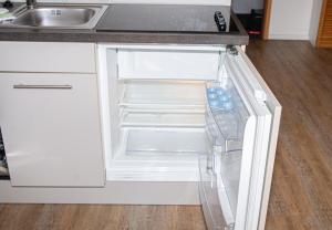 een lege koelkast met de deur open in een keuken bij Ostut in Norderney