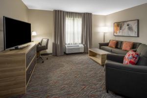 a living room with a flat screen tv and a couch at Candlewood Suites - Boston North Shore - Danvers, an IHG Hotel in Danvers