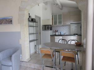 cocina y comedor con mesa y sillas en Domaine du bois gîte Bleuette, en Galargues