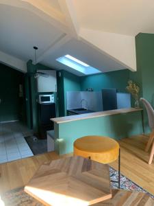 - une cuisine avec des murs verts et une table en bois dans l'établissement Magnifique Appartement Neuf Vieux Rouen, à Rouen