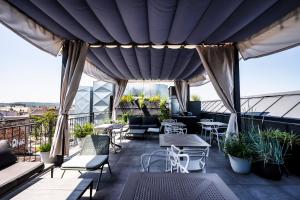 um p&aacute;tio com mesas e cadeiras numa varanda em Hotel Indigo Krakow - Old Town, an IHG Hotel em Crac&oacute;via