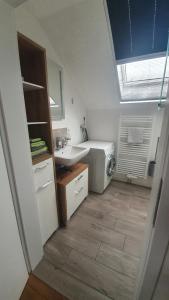 a bathroom with a sink and a washing machine at Zettis Ferienhäusle in Berg bei Ravensburg +29 photos