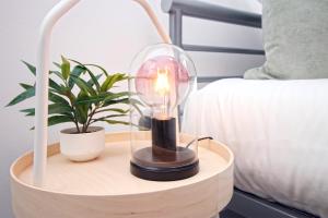 a lamp on a wooden table next to a bed at Dock House - 5 Bedroom House - Sleeps 7 in Newport