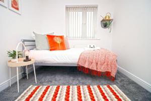 a white room with a bed with orange pillows and a table at Dock House - 5 Bedroom House - Sleeps 7 in Newport