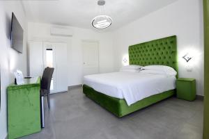 瓦尔蒙托内Agriturismo Borgo Imperiale的卧室里有一张大床，床头板是绿色的