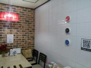 a dining room with a table and a brick wall at I Want Livingtel in Yongin
