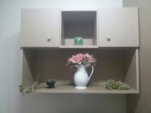 a white vase sitting on a shelf with flowers at I Want Livingtel in Yongin