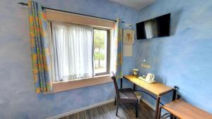 Cette chambre comprend un bureau, une fenêtre et une table. dans l'établissement Hotel du Mas, à Vinassan