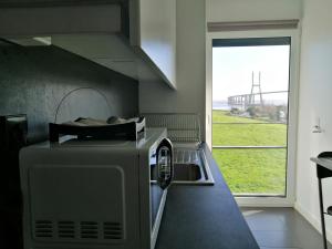 eine Küche mit einem Toaster, einem Backofen und einem Fenster in der Unterkunft Welcome Here - Tamisa - Parque das Nações in Lissabon