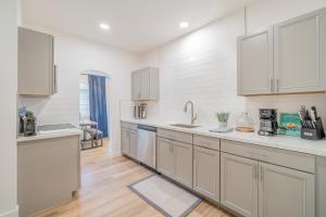 a kitchen with white cabinets and wooden floors at Plush 2-bed apt in Riverside Heights! in Reno