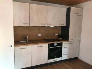 una cocina con armarios blancos y fregadero en Wenzels Ferienwohnung im Südschwarzwald, en Stühlingen