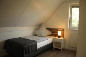 a small bedroom with a bed and a window at Haus am Vliet in Medemblik +46 photos