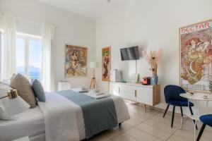 1 dormitorio con 1 cama, TV y mesa en Naro Suites and Rooms en Bacoli