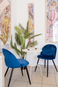 2 chaises bleues, une table et une plante dans l'établissement Naro Suites and Rooms, à Bacoli