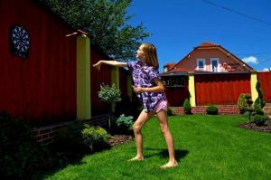 a young girl playing with a frisbee in a yard at Apartmány Riviéra & Vila Deluxe Liptov Bešeňová in Ružomberok