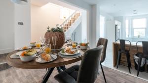 a dining room with a table with food on it at Tŷ Hapus Newport - Luxury 4 Bedroom Home in Newport