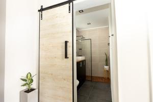 y baño con puerta corredera de cristal con ducha. en "El Farolito Apartment" en Buenos Aires