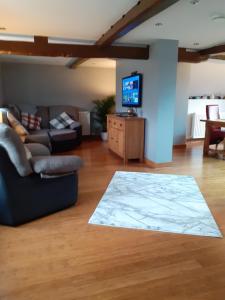 a living room with a couch and a flat screen tv at Riverside 2 bed apartment Bewdley Worcestershire in Bewdley
