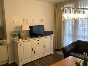 una sala de estar con TV en un armario blanco en Haus Anker Wohnung 9, en Norderney