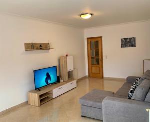 a living room with a couch and a flat screen tv at Apartamento saloio in Venda do Pinheiro