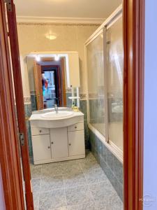a bathroom with a sink and a shower at Apartamento saloio in Venda do Pinheiro