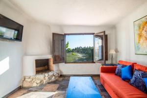sala de estar con sofá rojo y chimenea en Casa de campo mediterránea en Alicante, en Agost