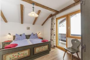 1 dormitorio con 1 cama, 1 silla y 1 ventana en Mitterwallnerhof en Schladming