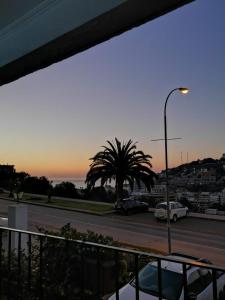a parking lot with a palm tree and a street light at Departamento La Palmera in Viña del Mar