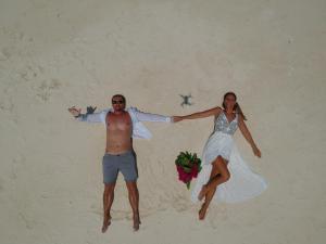 Un homme et une femme sautant sur la plage dans l'établissement Thoddoo Sun Sky Inn, Maldives, à Thoddoo