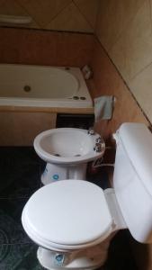 ein Badezimmer mit einem WC, einem Waschbecken und einer Badewanne in der Unterkunft 9 de julio in Villa Mercedes