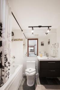 uma casa de banho com um WC, uma banheira e um lavatório. em Attractive Townhouse in Whistler Village with Hot Tub em Whistler