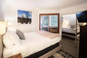um quarto com uma cama, uma televisão e uma janela em Attractive Townhouse in Whistler Village with Hot Tub em Whistler
