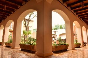 an arcade in a building with potted plants at Hotel Junvay in San Cristóbal de Las Casas