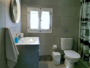 a bathroom with a toilet and a sink and a window at Anastasia's house Ysterni in Isterni
