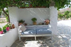 a white bench sitting on a patio with potted plants at Anastasia's house Ysterni in Isterni
