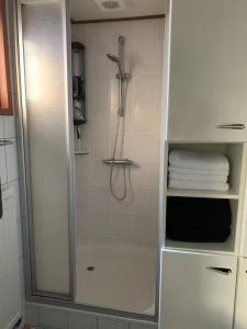 een badkamer met een douche en een witte kast bij Privé chalet op vakantiepark Marina Beach in Hoek