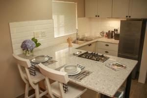 a kitchen with a counter top with a table and chairs at Idavold Gate House in Howick