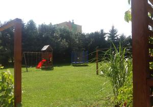 um quintal com um parque infantil com baloiços em Apartamenty-Obok 2 em Zator