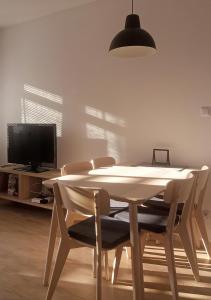 uma mesa e cadeiras numa sala de estar com televisão em Apartamenty-Obok 2 em Zator