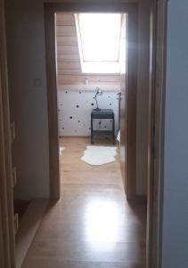 um quarto vazio com uma janela e um quarto com piso em madeira em Apartamenty-Obok 2 em Zator