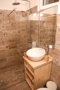 a bathroom with a sink and a glass shower at Apartamentul 16 in Braşov