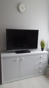 a white entertainment center with a flat screen tv on top at Kleine Oase bei Nina in Zorge