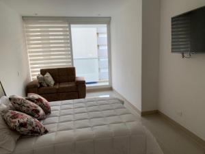 - une chambre avec un lit, un canapé et une fenêtre dans l'établissement Edificio kuali apto 1704, à Santa Marta