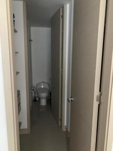 d'un couloir menant à une salle de bains pourvue de toilettes. dans l'établissement Edificio kuali apto 1704, à Santa Marta