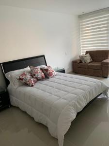 - un grand lit blanc dans une chambre avec un canapé dans l'établissement Edificio kuali apto 1704, à Santa Marta