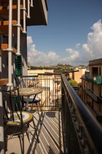 un patio con tavoli e sedie su un balcone di alfaapartment & beautiful 20-metre terrace a Casteldaccia