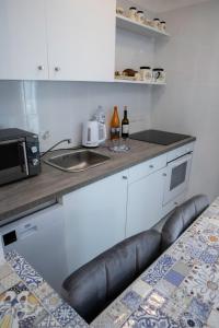 una piccola cucina con lavandino e forno a microonde di alfaapartment & beautiful 20-metre terrace a Casteldaccia