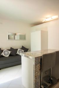 una cucina e un soggiorno con bancone e divano di alfaapartment & beautiful 20-metre terrace a Casteldaccia